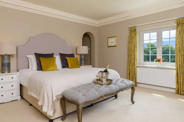A King room at Kenmare House with antique furnishings and a large bed