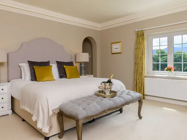 A King room at Kenmare House with antique furnishings and a large bed